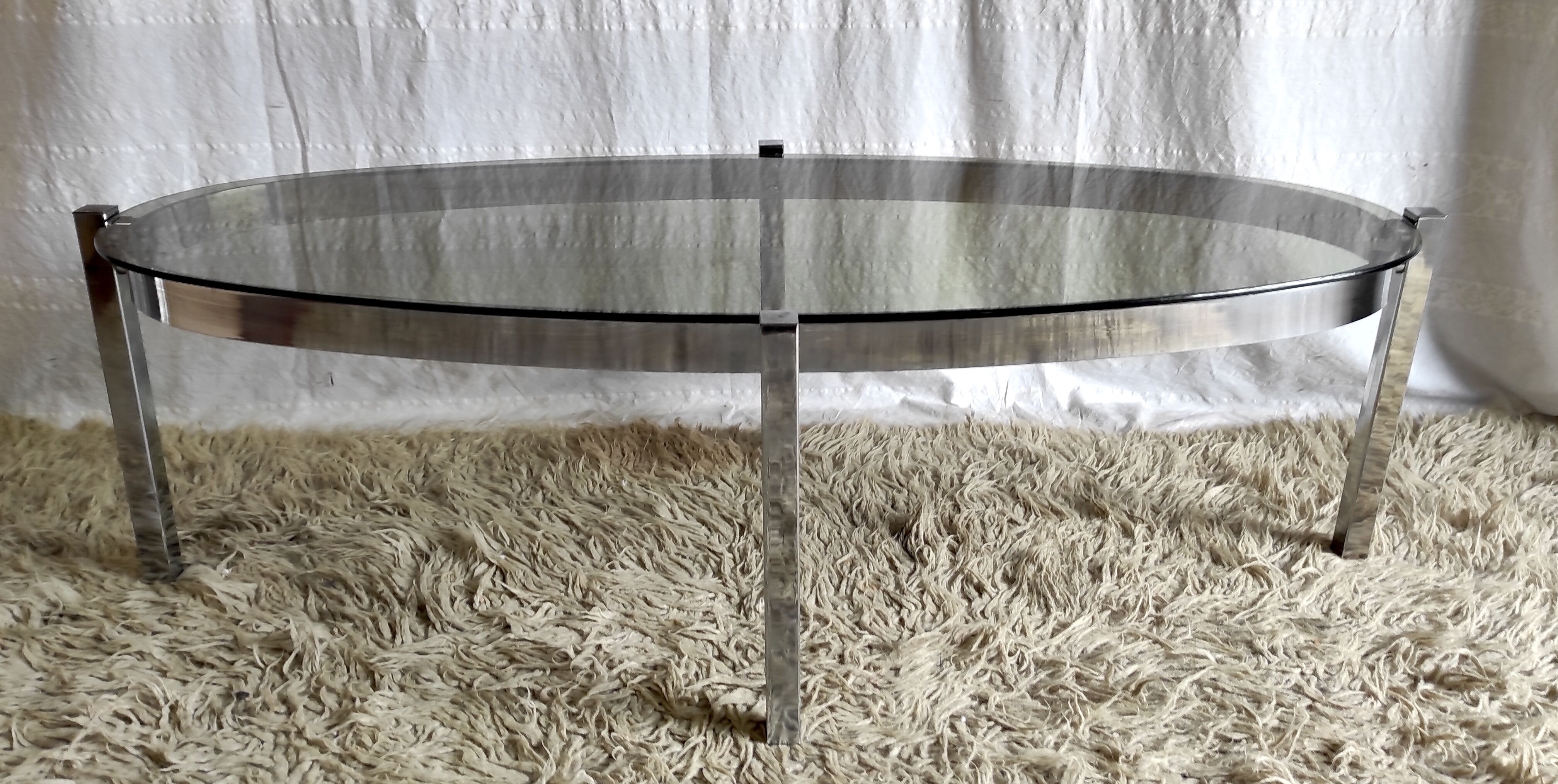 Table basse de forme élyptique en metal chomé et verre fumé, années 70