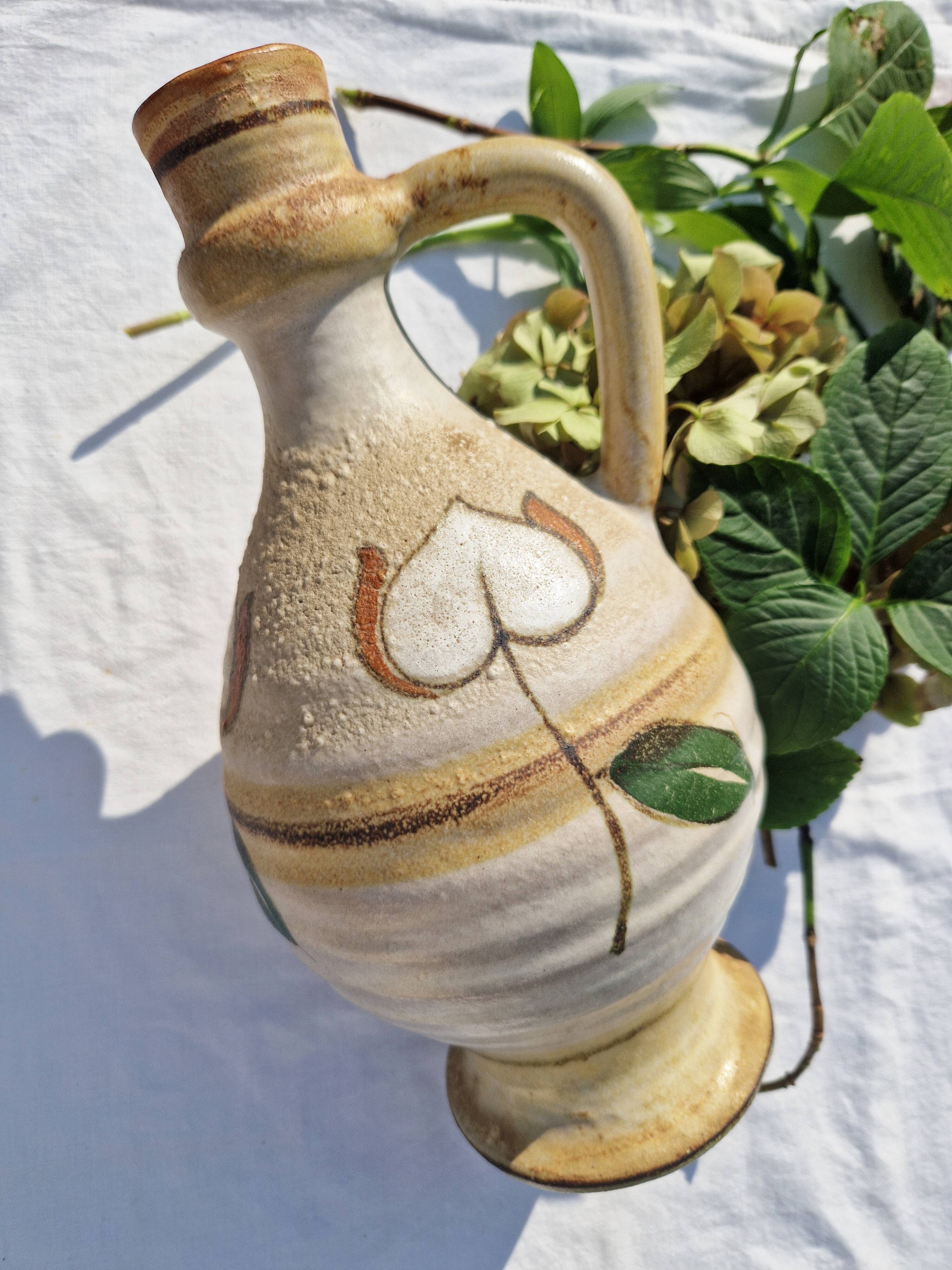 Handcrafted jug or jar with a handle, terracotta pottery vase, fat lava effect, stylized flowers