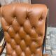 Chesterfield armchair in leather and carved solid wood