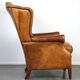 Positively lived-in sheepskin leather wing chair with pleasant seating comfort
