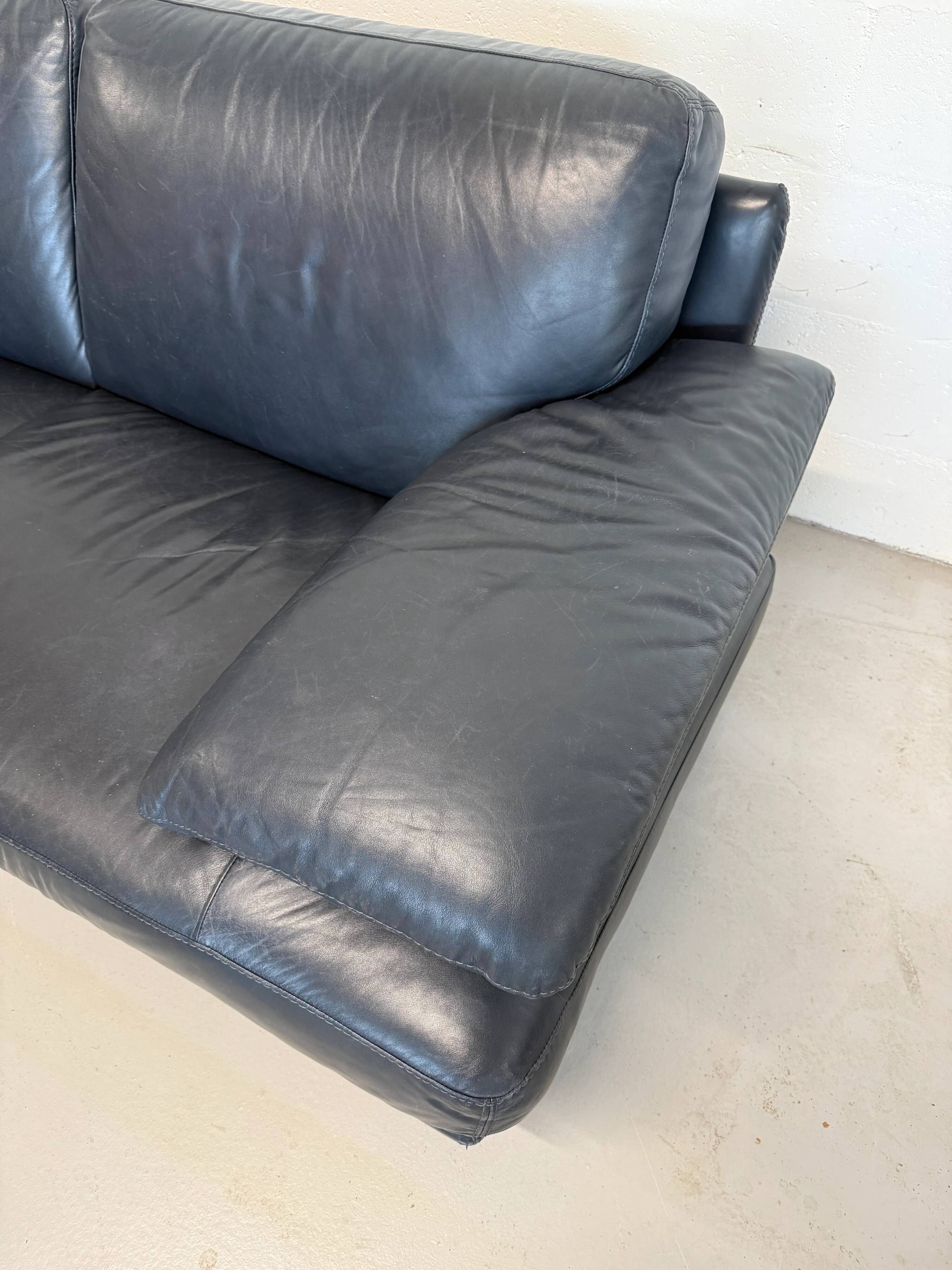 Two-seater Natuzzi sofa in navy blue leather.