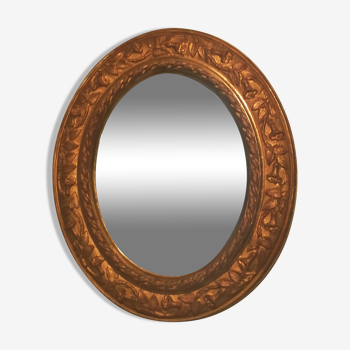 Oval art nouveau mirror in gilded stucco, 50x42 cm