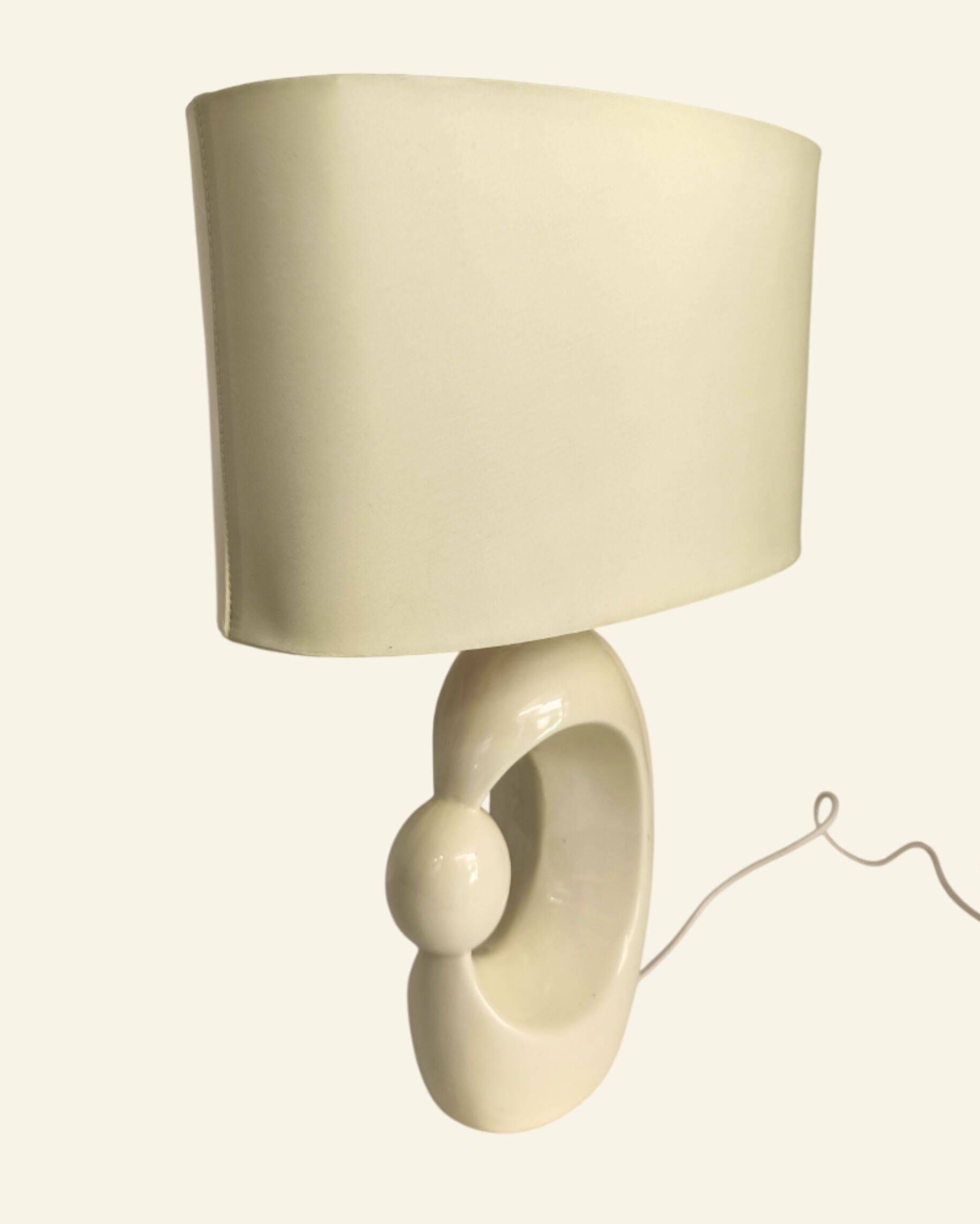 Cream ceramic table lamp with a mid-century design, featuring a lampshade.