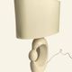 Cream ceramic table lamp with a mid-century design, featuring a lampshade.