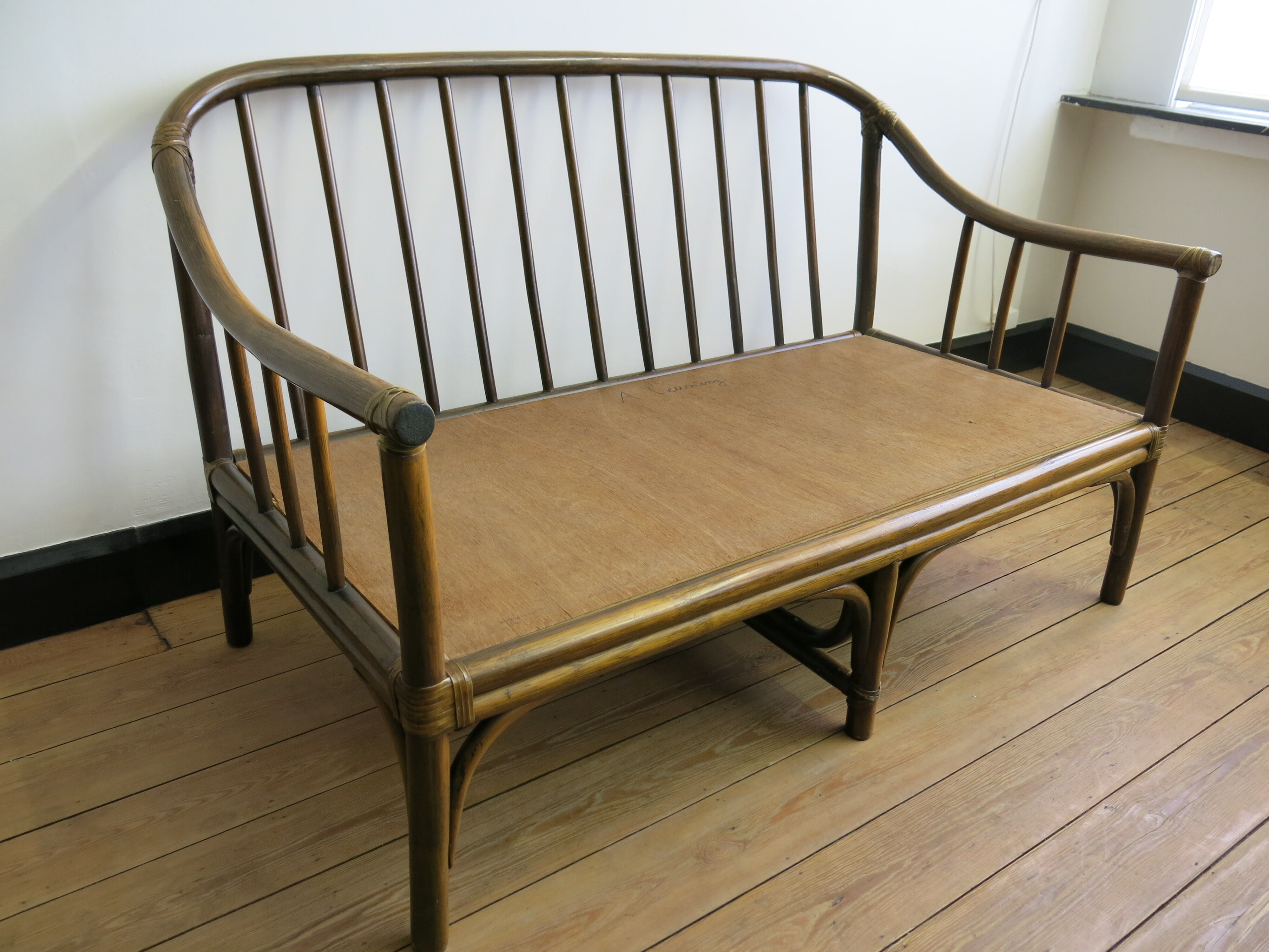 Two-seater rattan sofa with natural tones