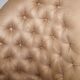 Chesterfield armchair in hardwood, leather, and woven linen.