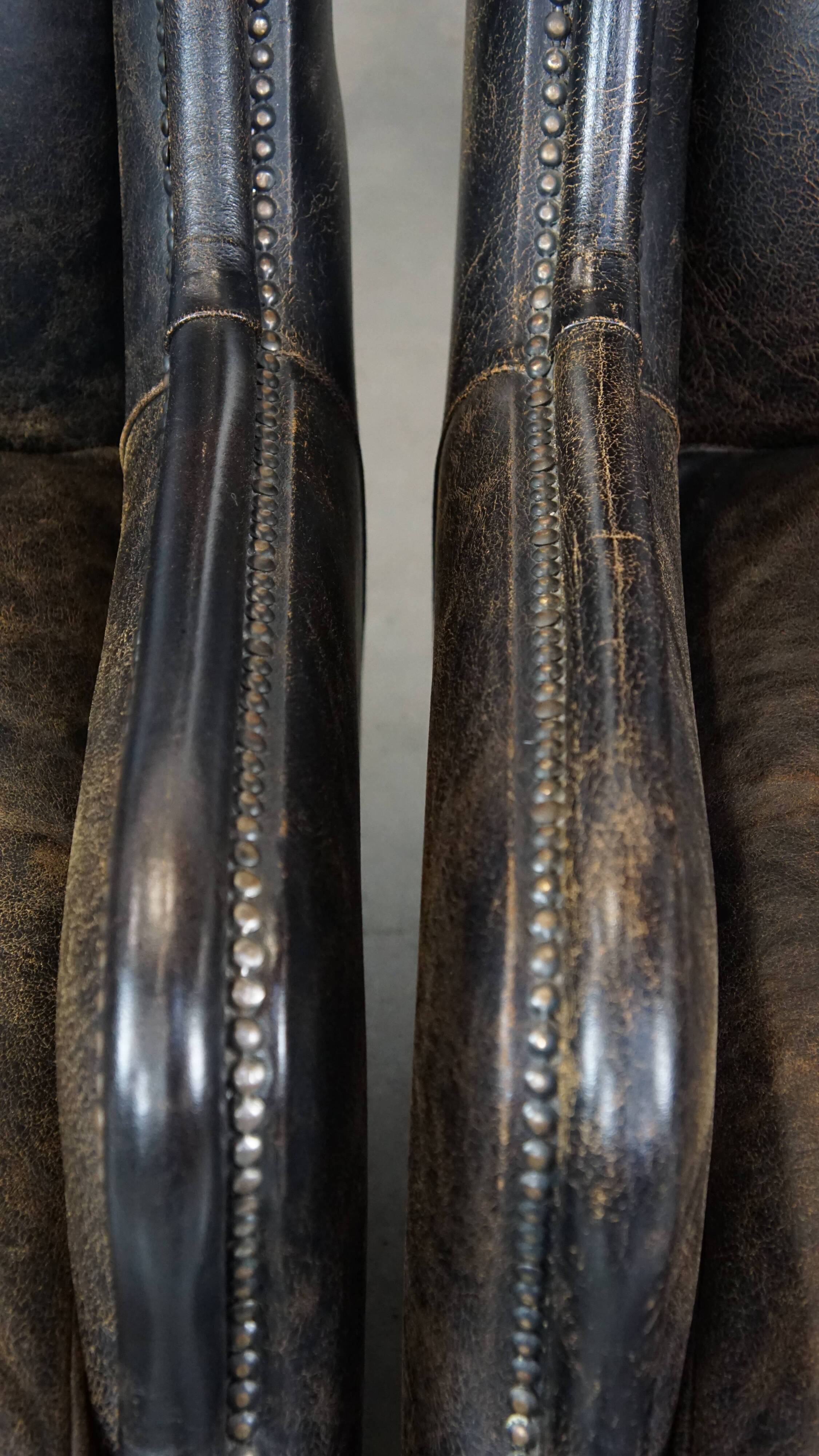 Set of 2 black cow leather armchairs finished with decorative nails, industrial style