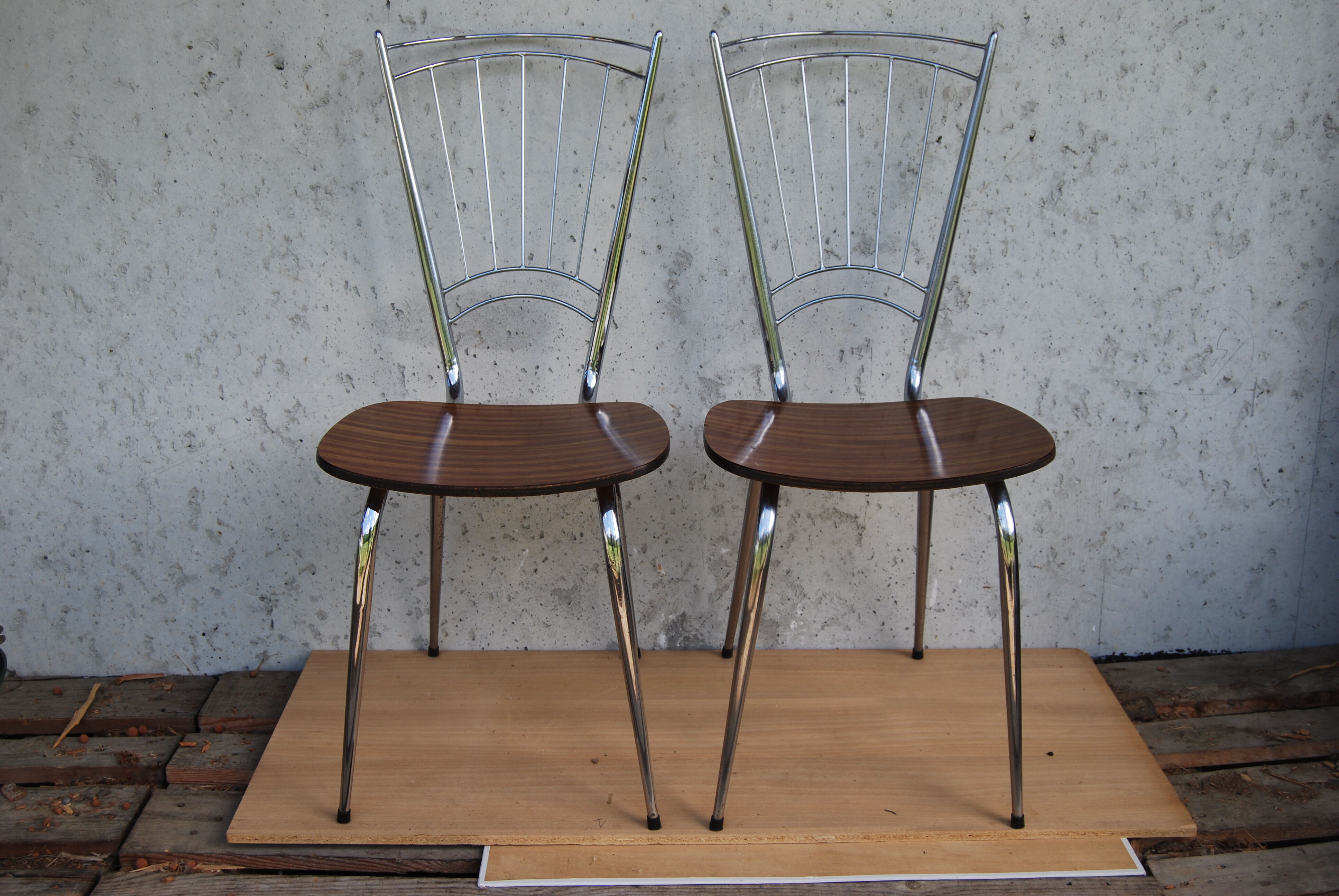 Pair of formica chairs with chrome metal backs in the shape of a lyre.