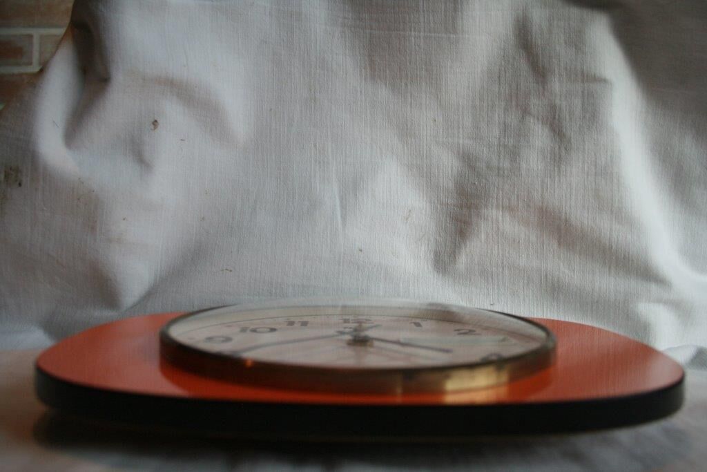 Vintage wall clock in orange formica