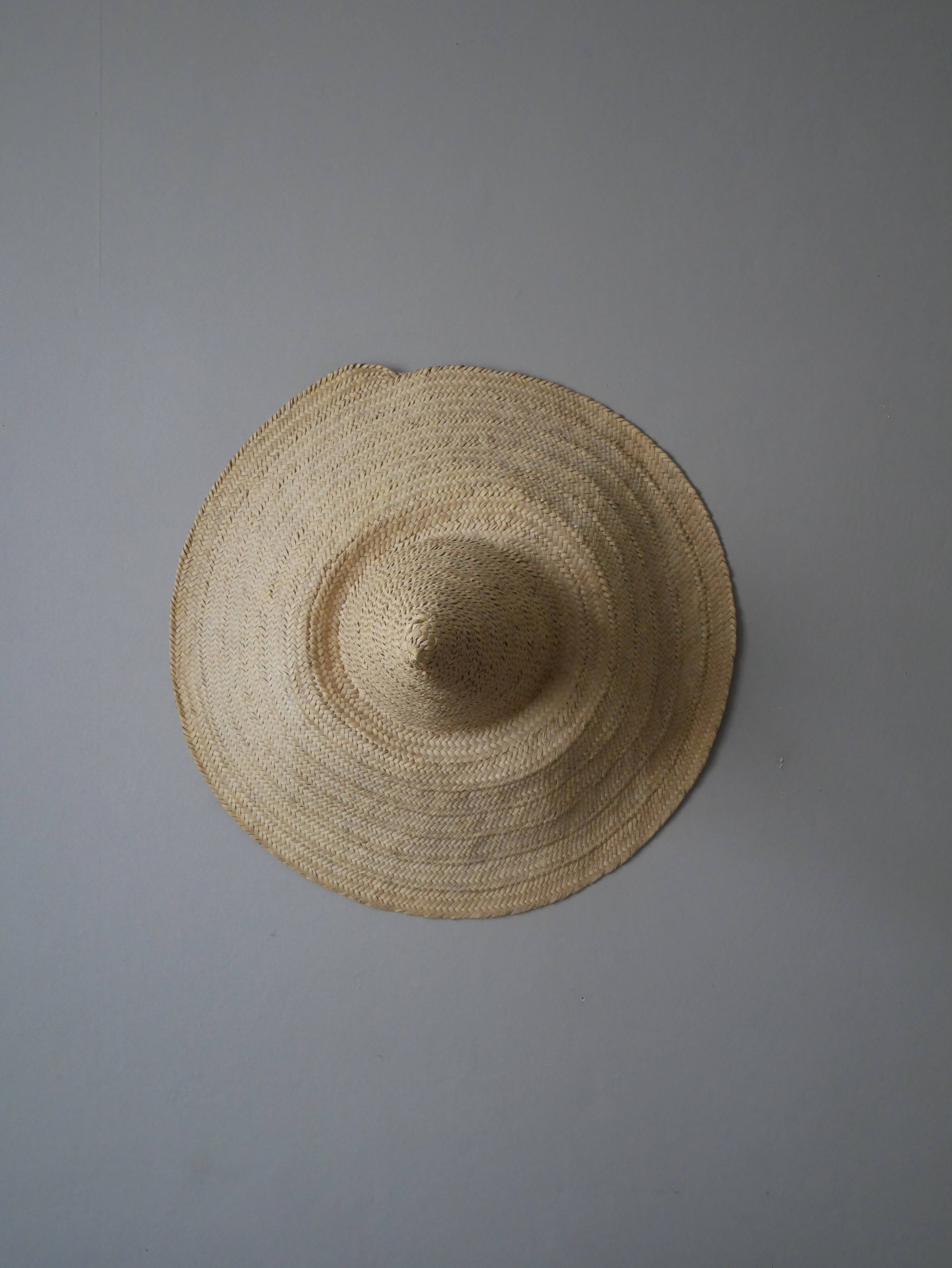 Hand-woven wicker straw hat, artisanal production, decorative object, bohemian ethnic countryside