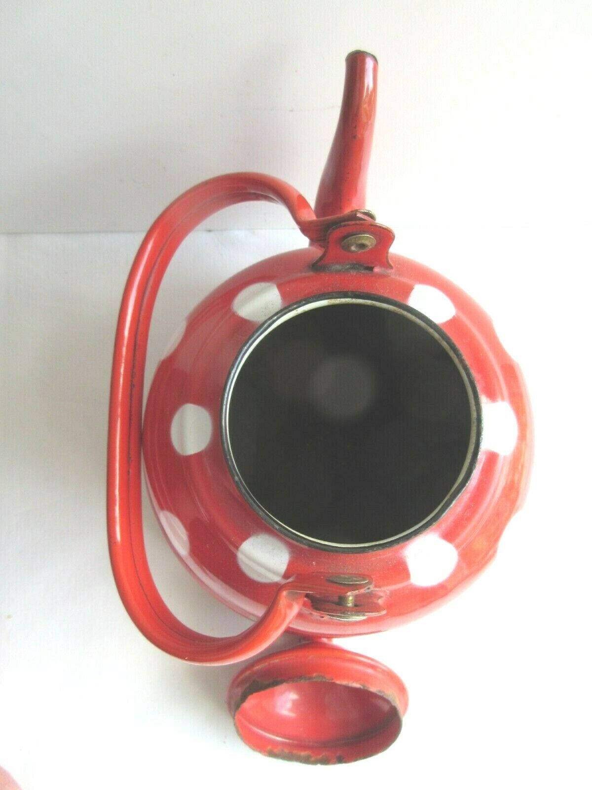 Old vintage kettle in red enamelled sheet metal, with white polka dots