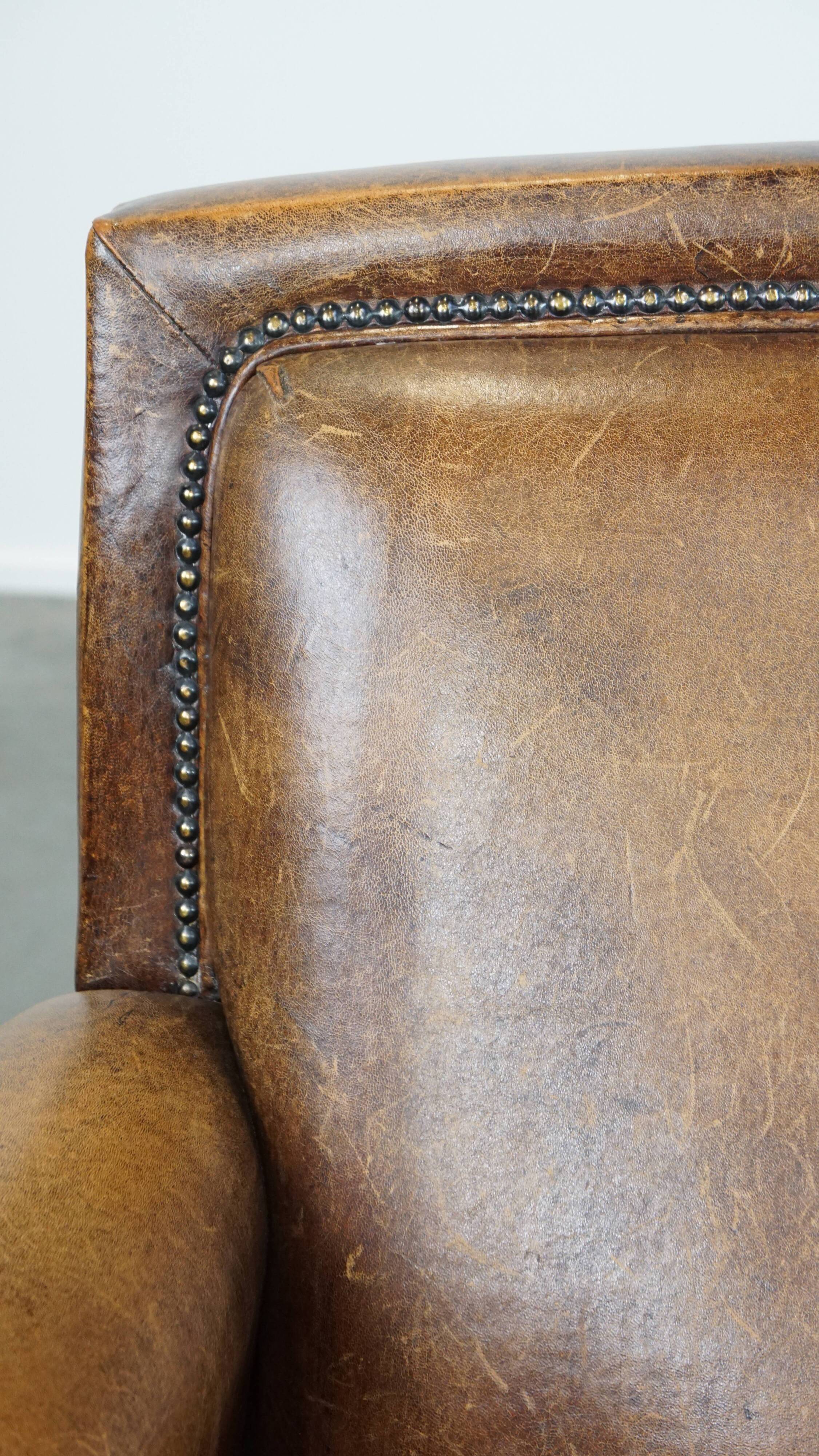 Armchair made of sheep leather finished with decorative nails