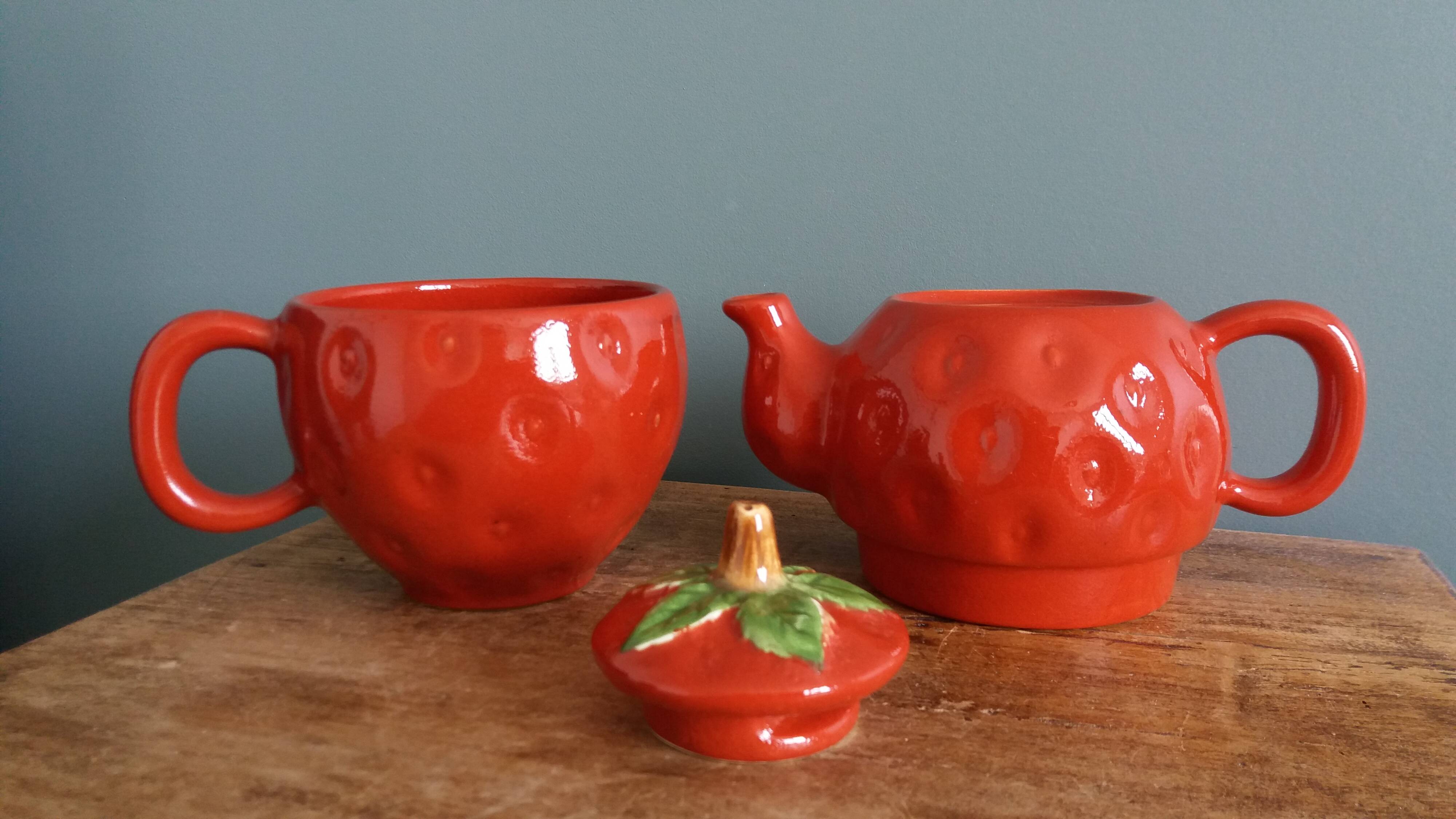 Teapot and cup in the shape of a strawberry.