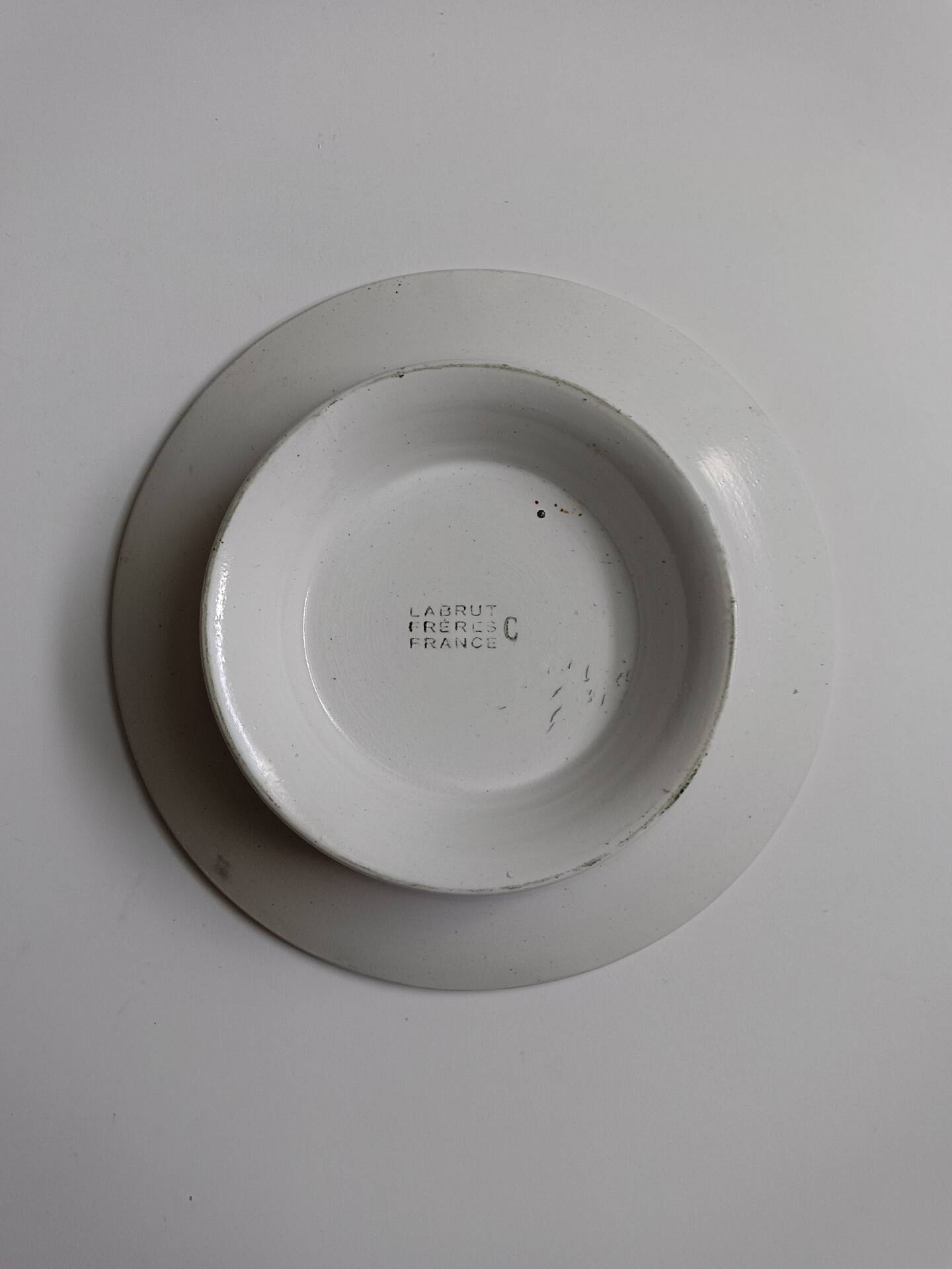 Old round footed plate signed Labrut brothers flowers