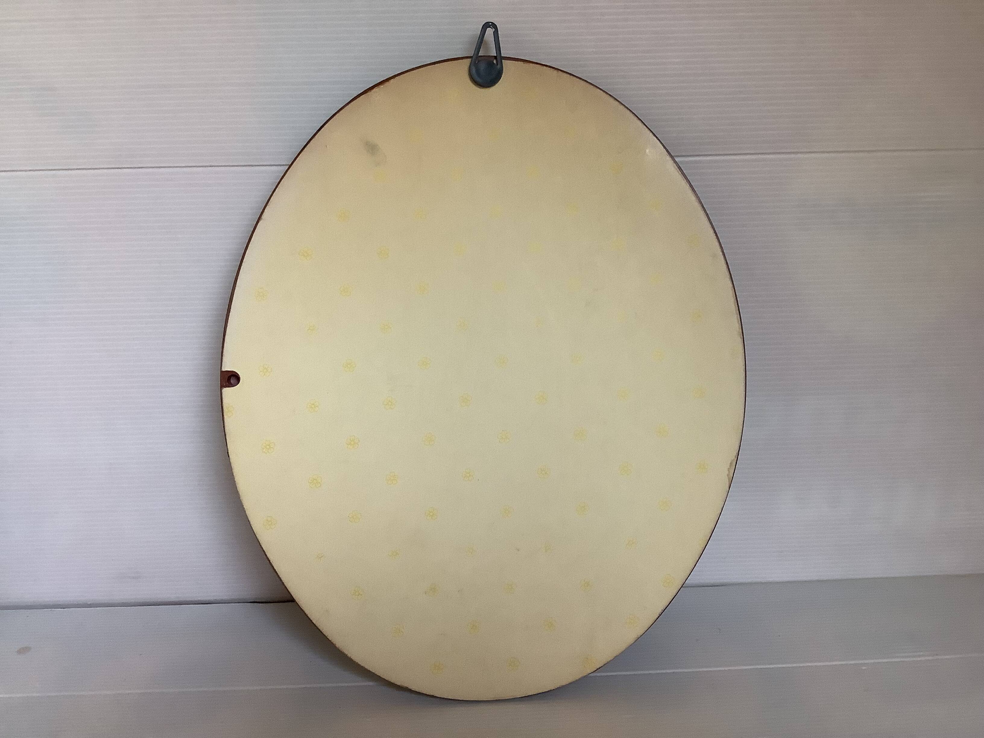 Oval painting of a bouquet of flowers, oil on panel.