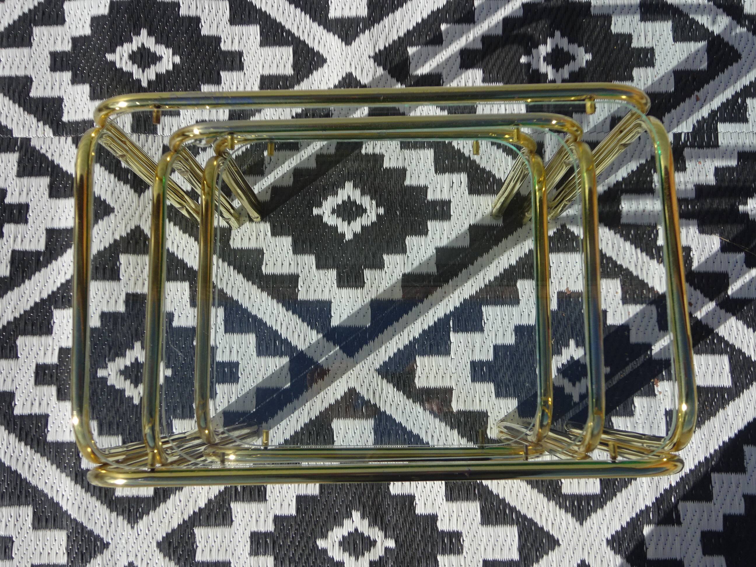 Nested tubular tables in gold metal.