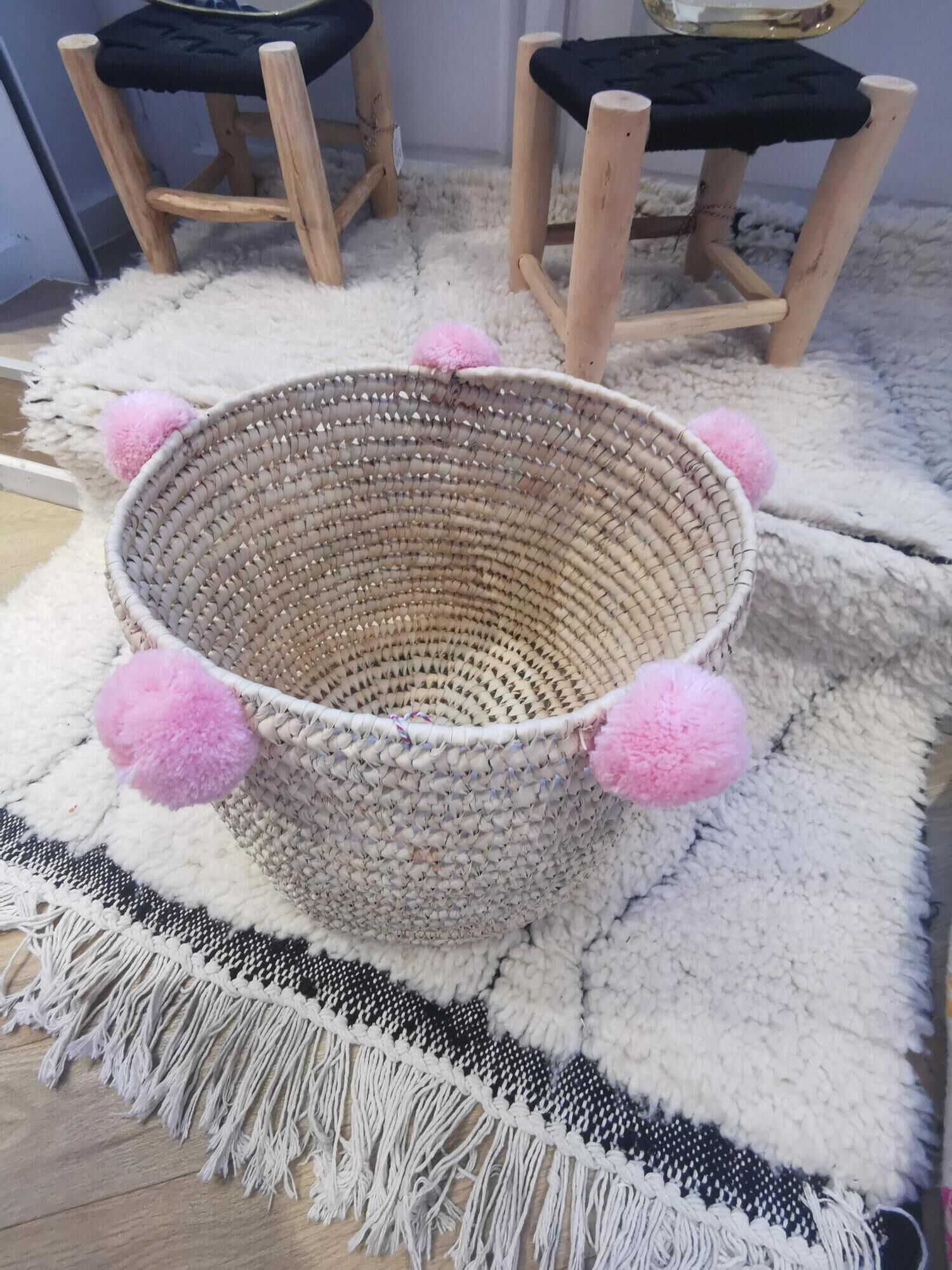 Moroccan basket with pale pink pompoms made of palm fiber