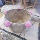 Moroccan basket with pale pink pompoms made of palm fiber