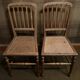 Set of 2 antique wooden chairs with caned seats.