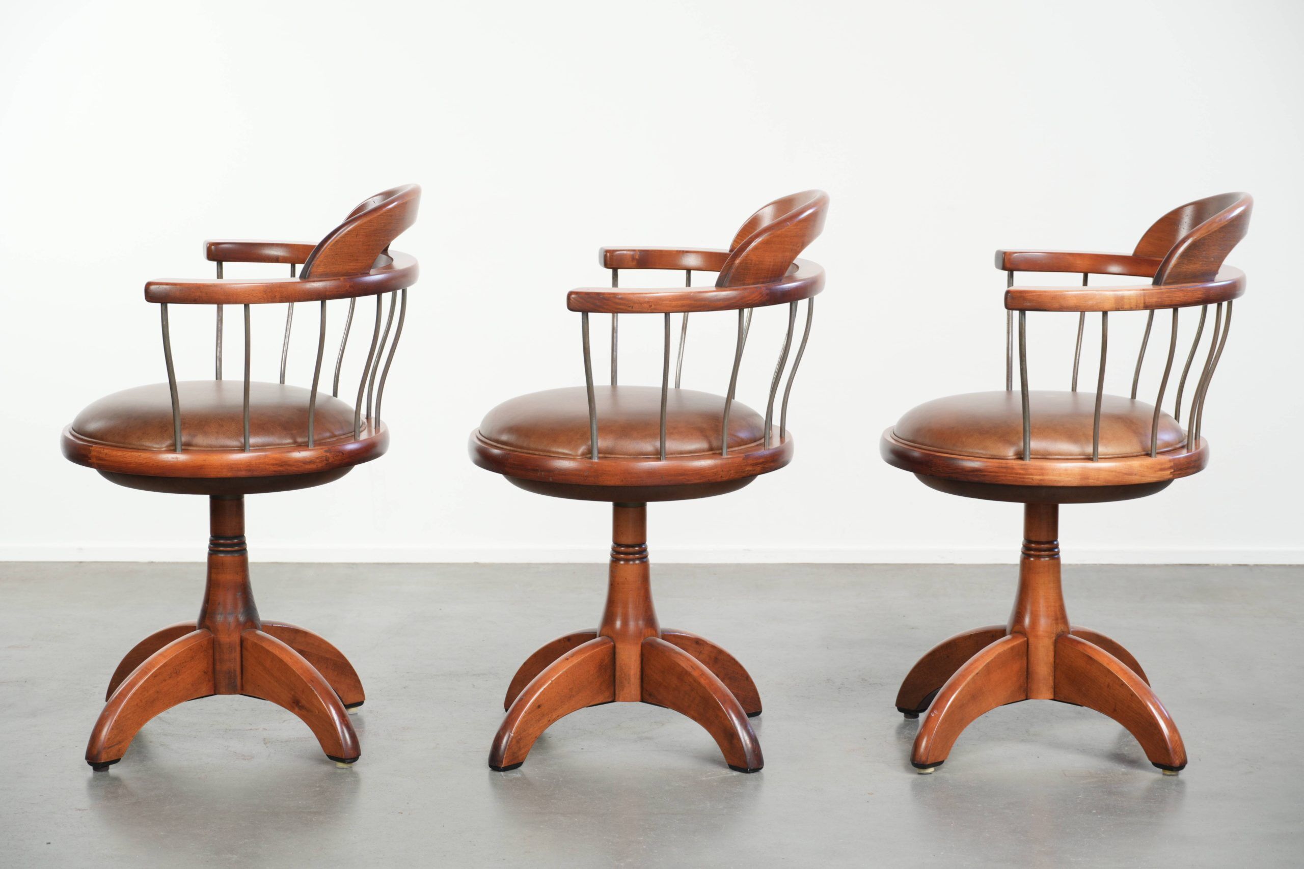 Ensemble de 3 chaises de bureau / de côté pivotantes avec un siège en cuir de vache couleur cognac.