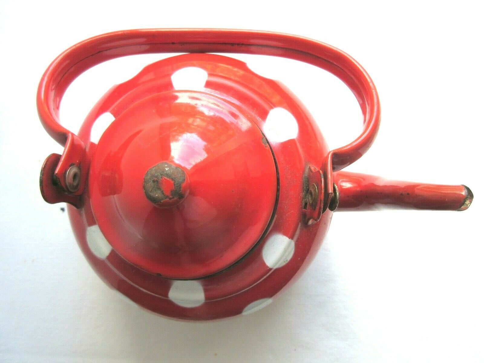Old vintage kettle in red enamelled sheet metal, with white polka dots