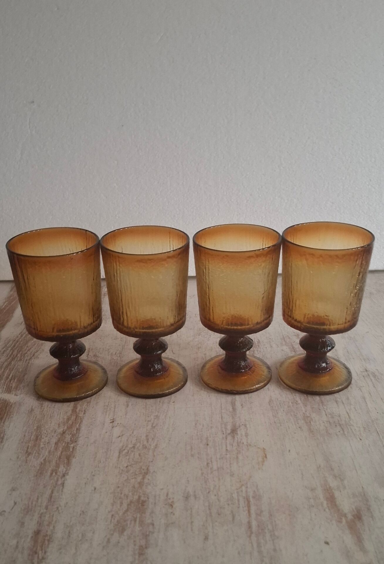 Set of four thick amber glass stemmed glasses.
