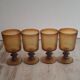 Set of four thick amber glass stemmed glasses.