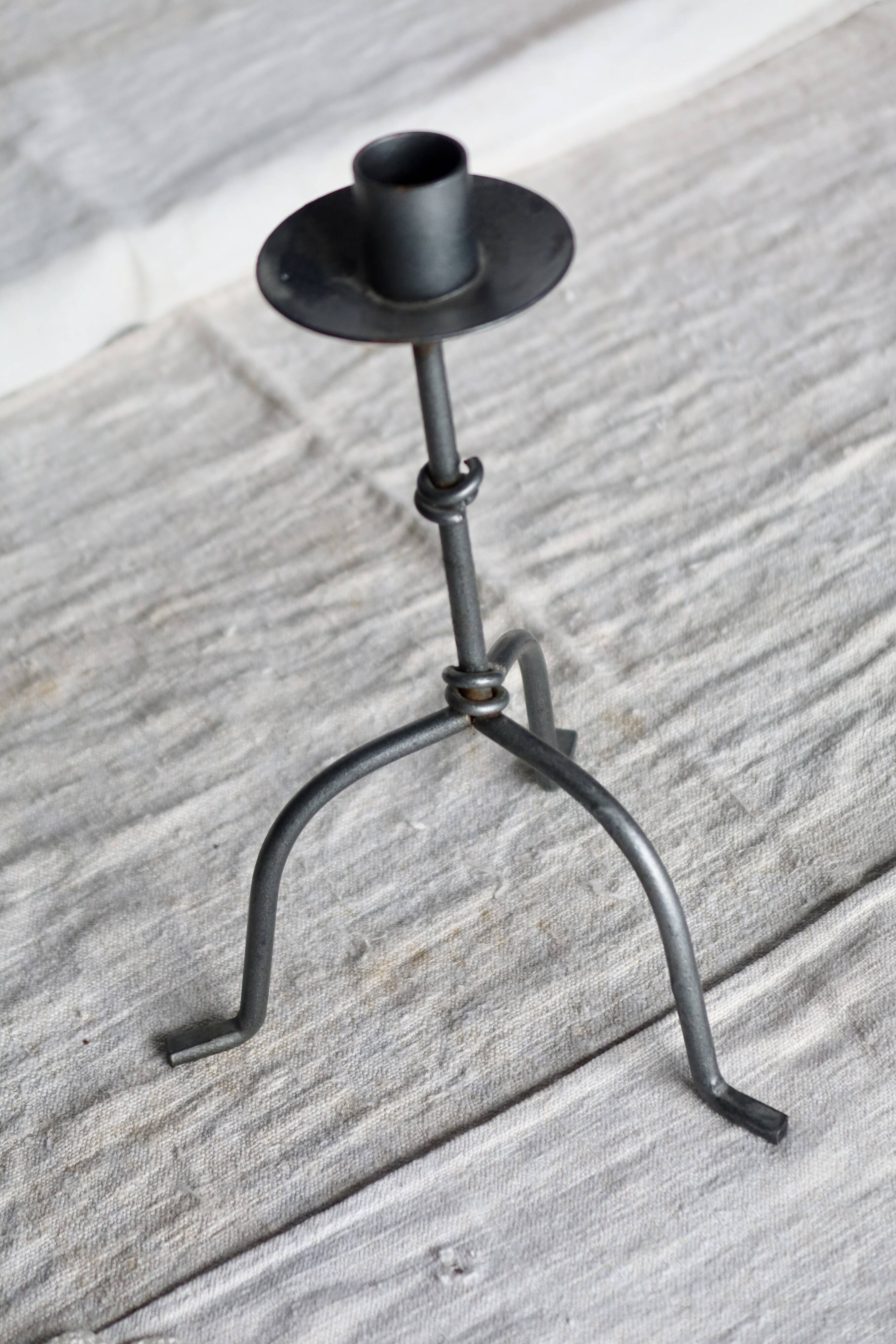 Antique tripod metal candlestick with knot decoration