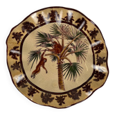 Plat en faïence craquelée à décor exotique de singes et palmiers, première moitié du XXe siècle.