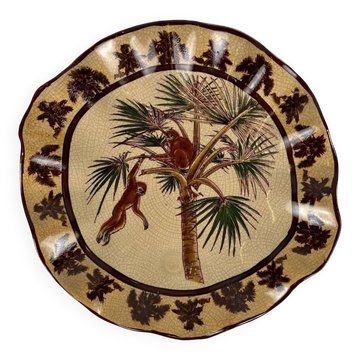 Plat en faïence craquelée à décor exotique de singes et palmiers, première moitié du XXe siècle.