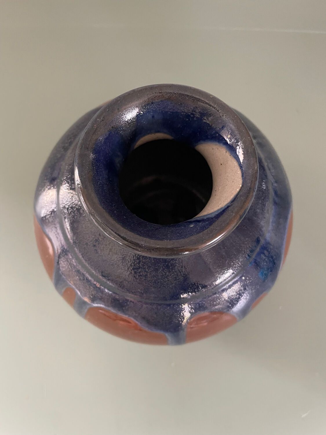 Old blue and brown vase with drips.