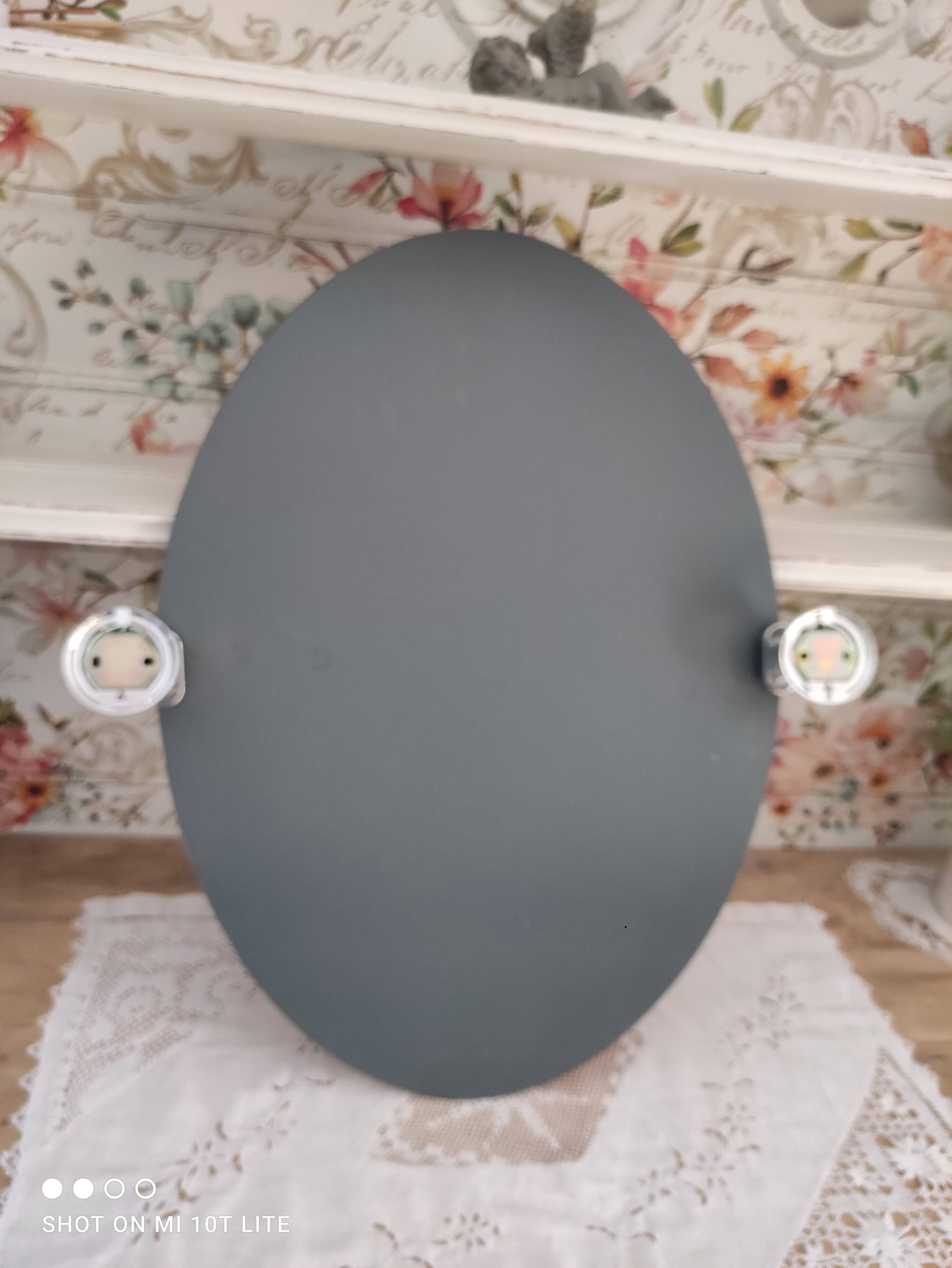Miroir ovale biseauté vintage années 70 avec ses accroches murales en métal couleur argent
