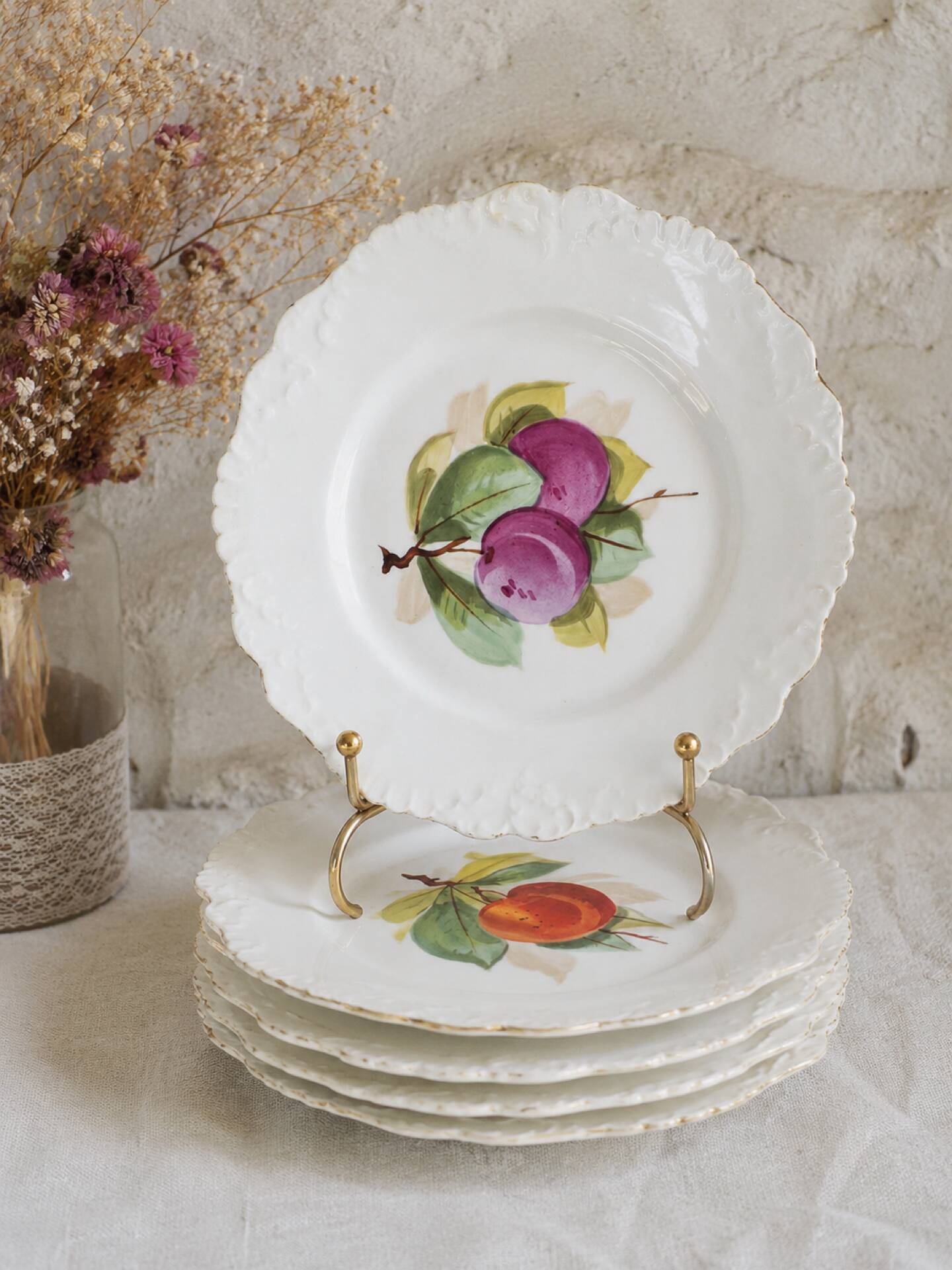 Antique plates from the late 19th century with scalloped edges and fruit decoration.