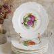 Antique plates from the late 19th century with scalloped edges and fruit decoration.