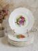 Antique plates from the late 19th century with scalloped edges and fruit decoration.