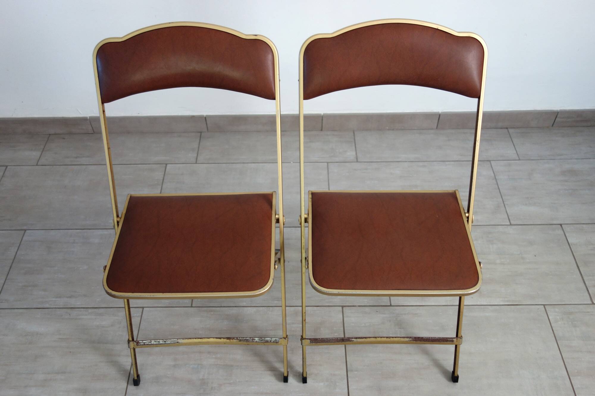 2 golden metal chairs with faux leather in the 60s/70s Opera style.