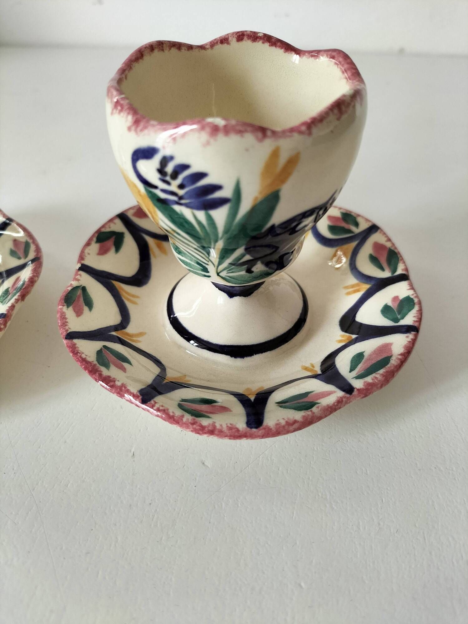 Pair of HB Quimper egg cups with integrated pedestal base, floral decoration