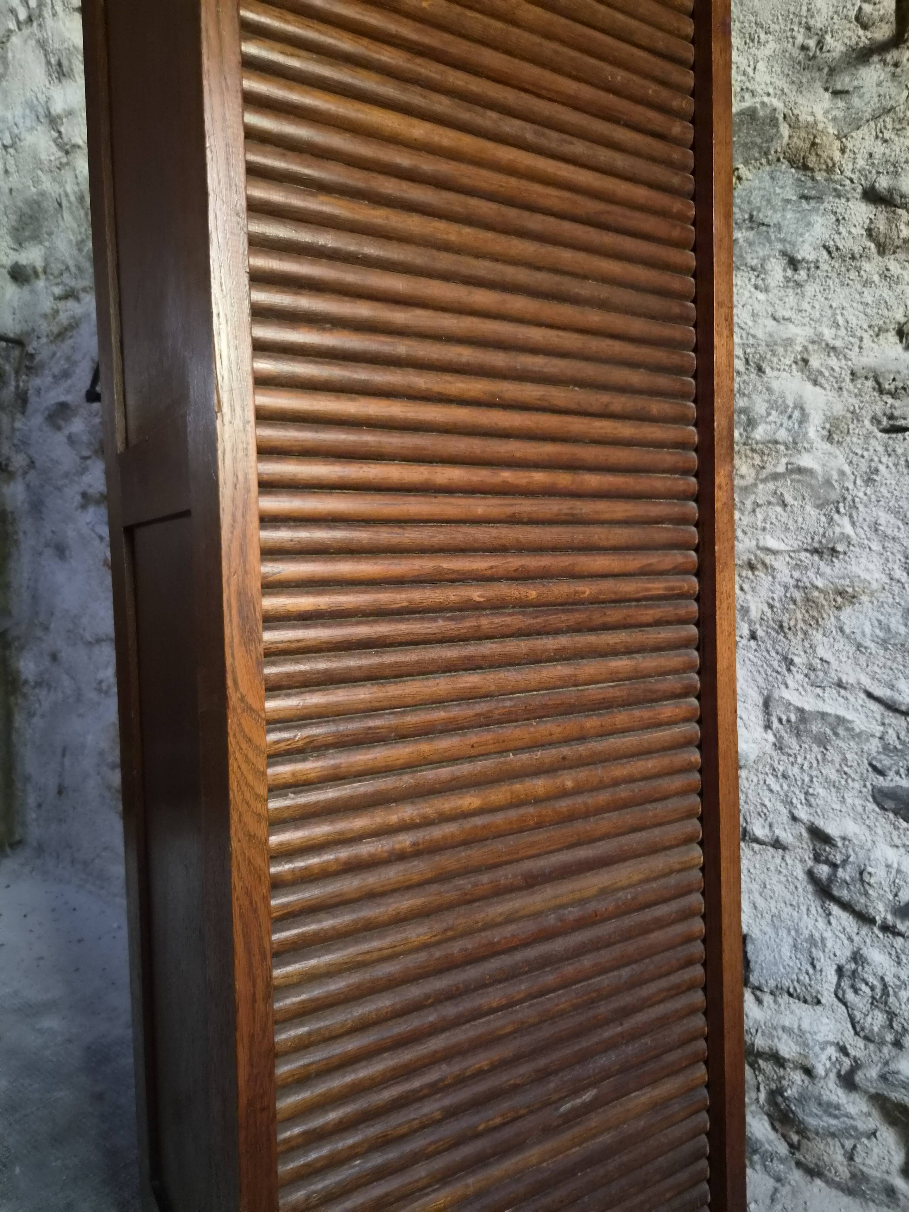 French antique wardrobe with curtain in oak, circa 1920–1930.