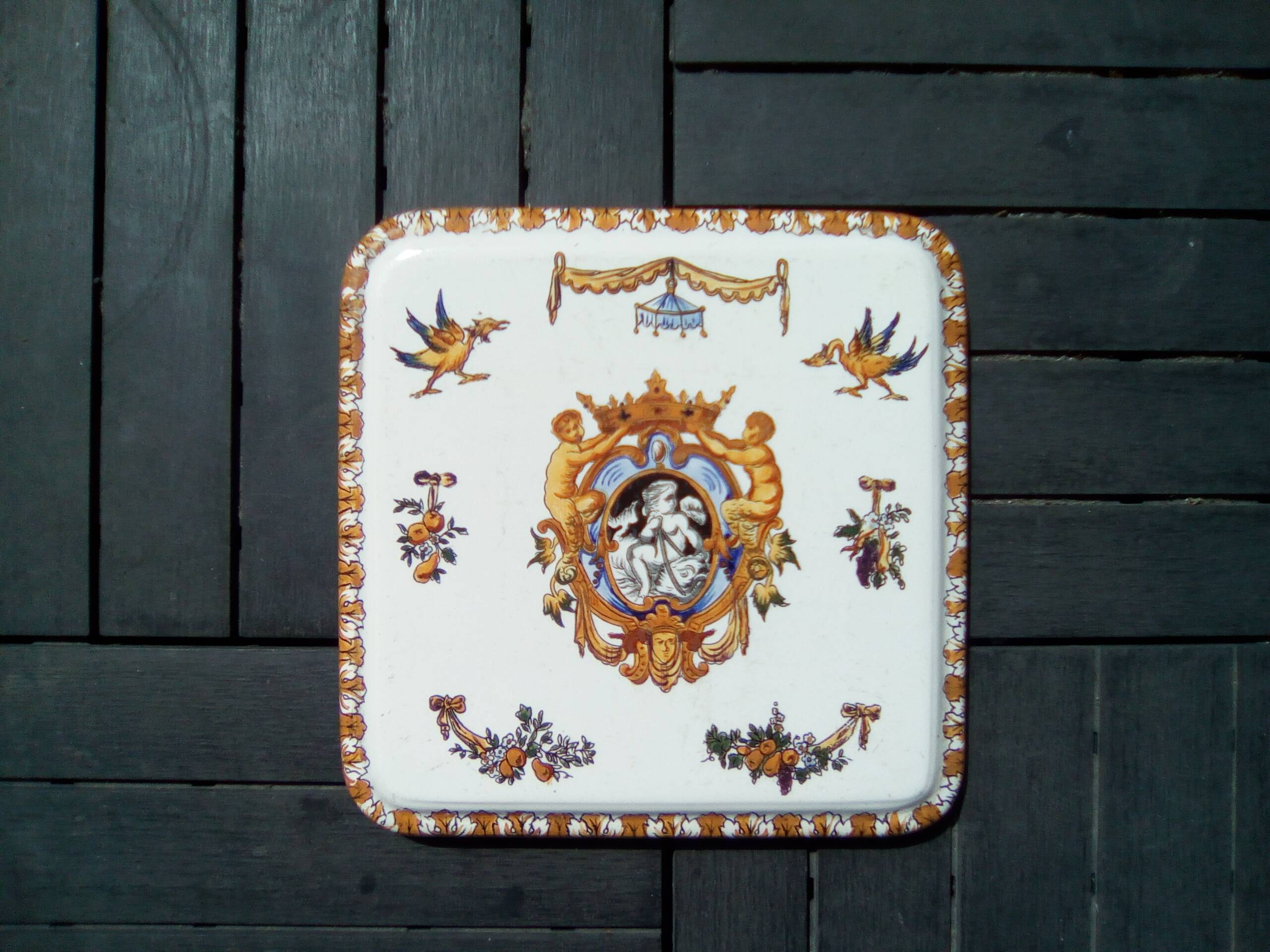 Square trivet with Renaissance decoration with poultry and sheaves of fruit.