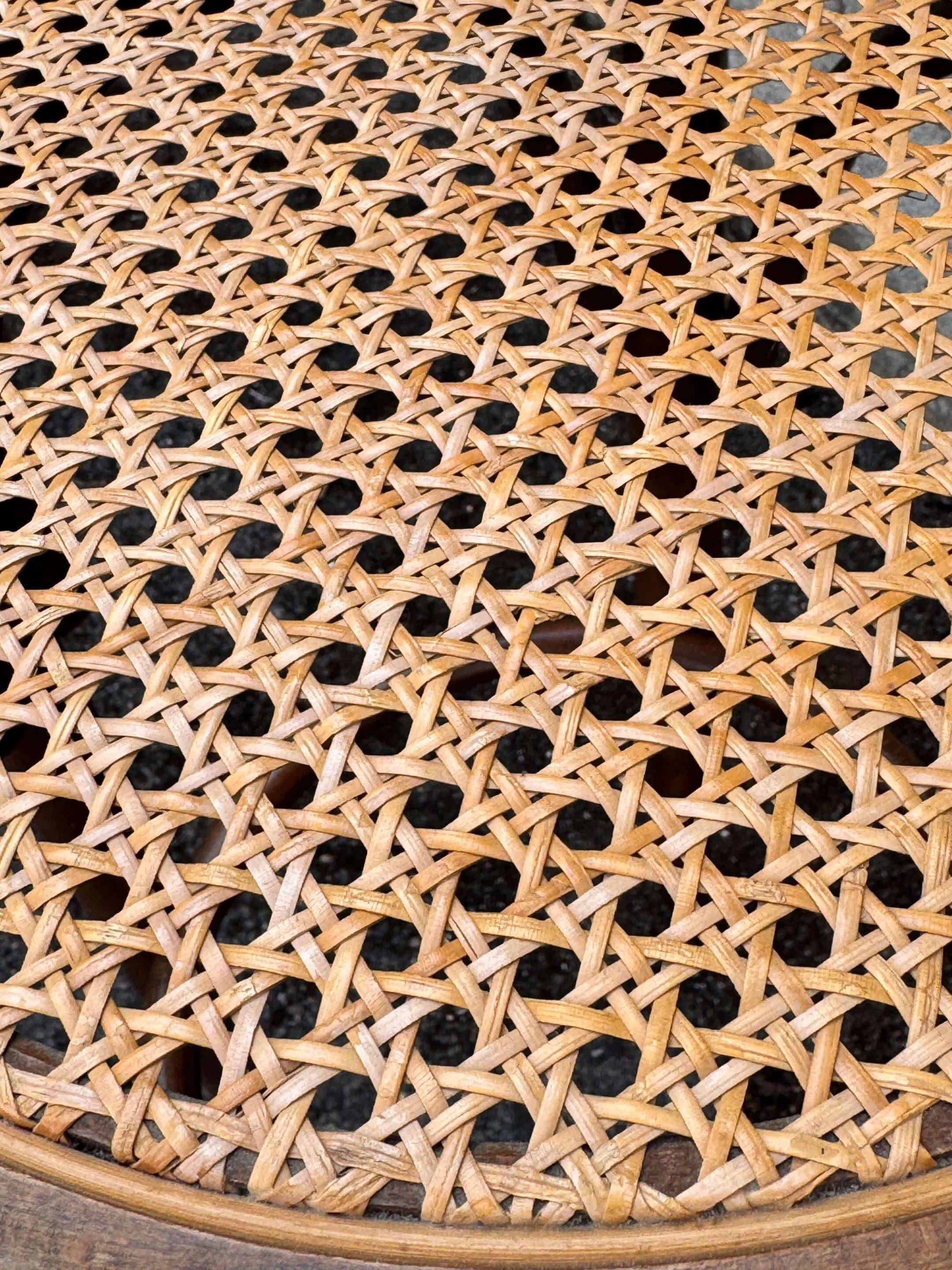 Old high stool in curved wood with caned seat