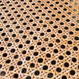 Old high stool in curved wood with caned seat