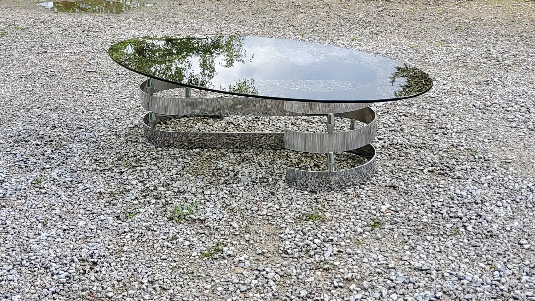 Oval coffee table of the 70s chromed metal base in s smoked glass top