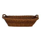 Vintage brown wicker baguette basket, elongated shape, with integrated handles.
