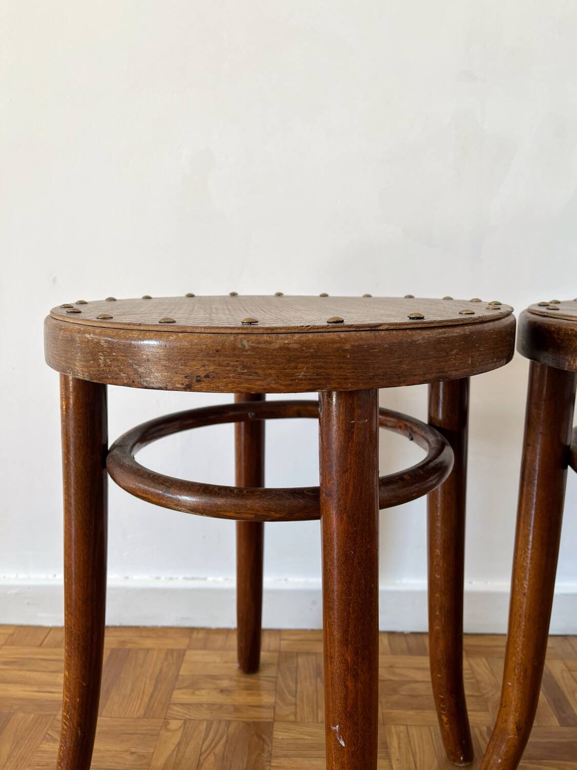 2 antique bistro stools with curved wood and caning effect.