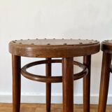 2 antique bistro stools with curved wood and caning effect.