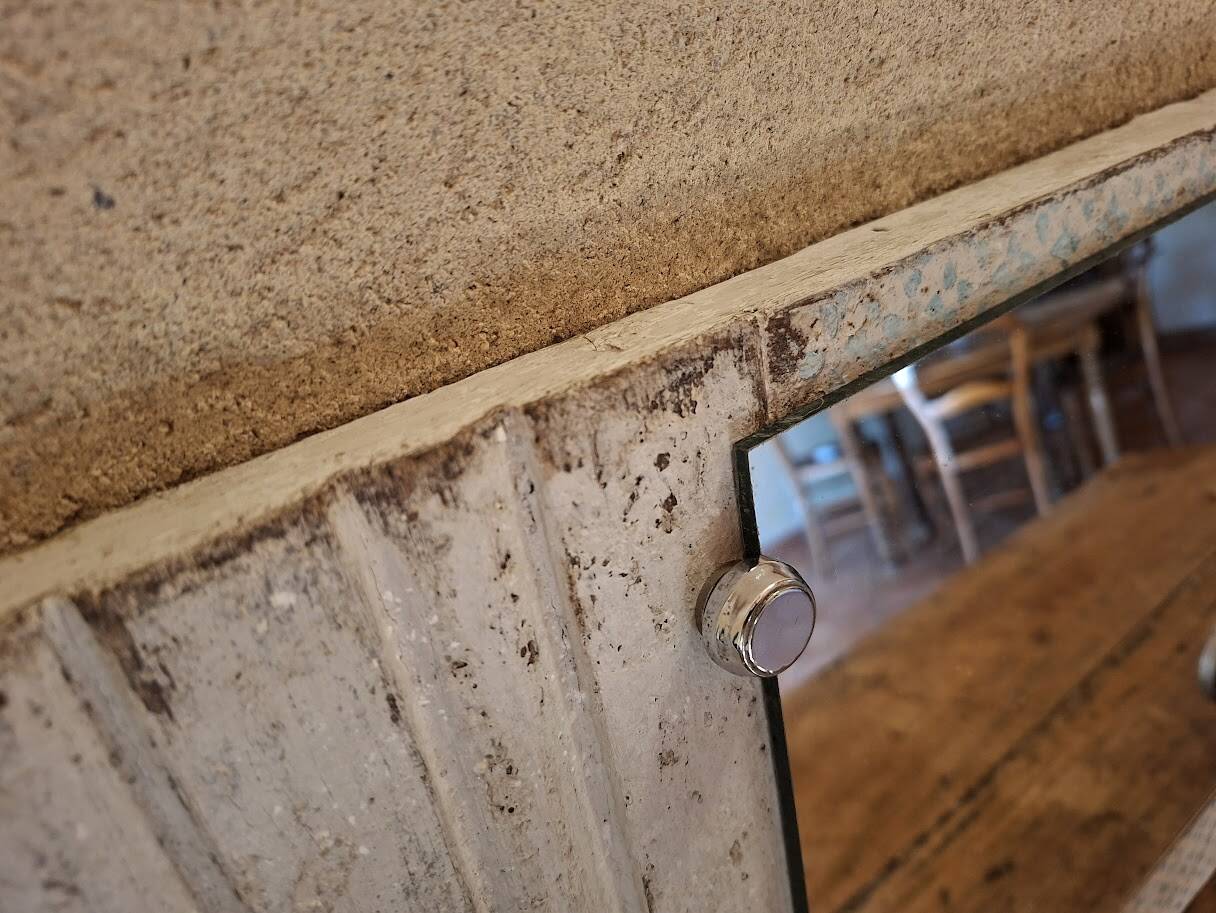 Wall-mounted coat rack with a patinated mirror