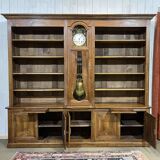 Library in walnut and oak from the early 20th century with its central clock.