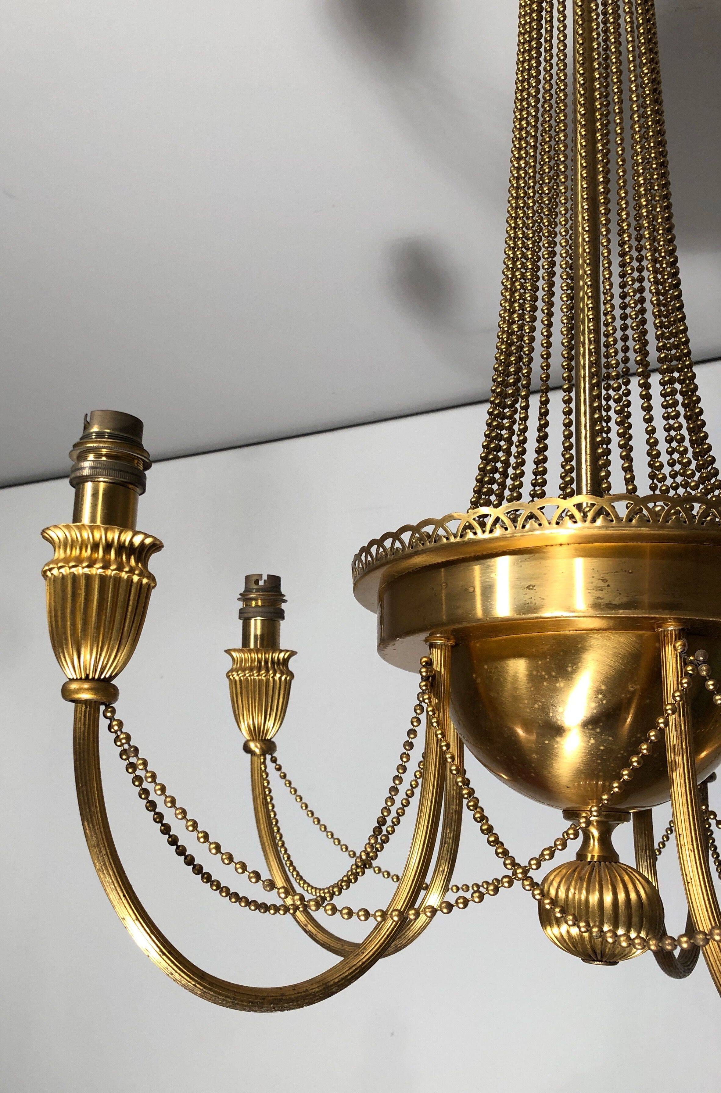 Neoclassical style brass chandelier decorated with pearl garlands