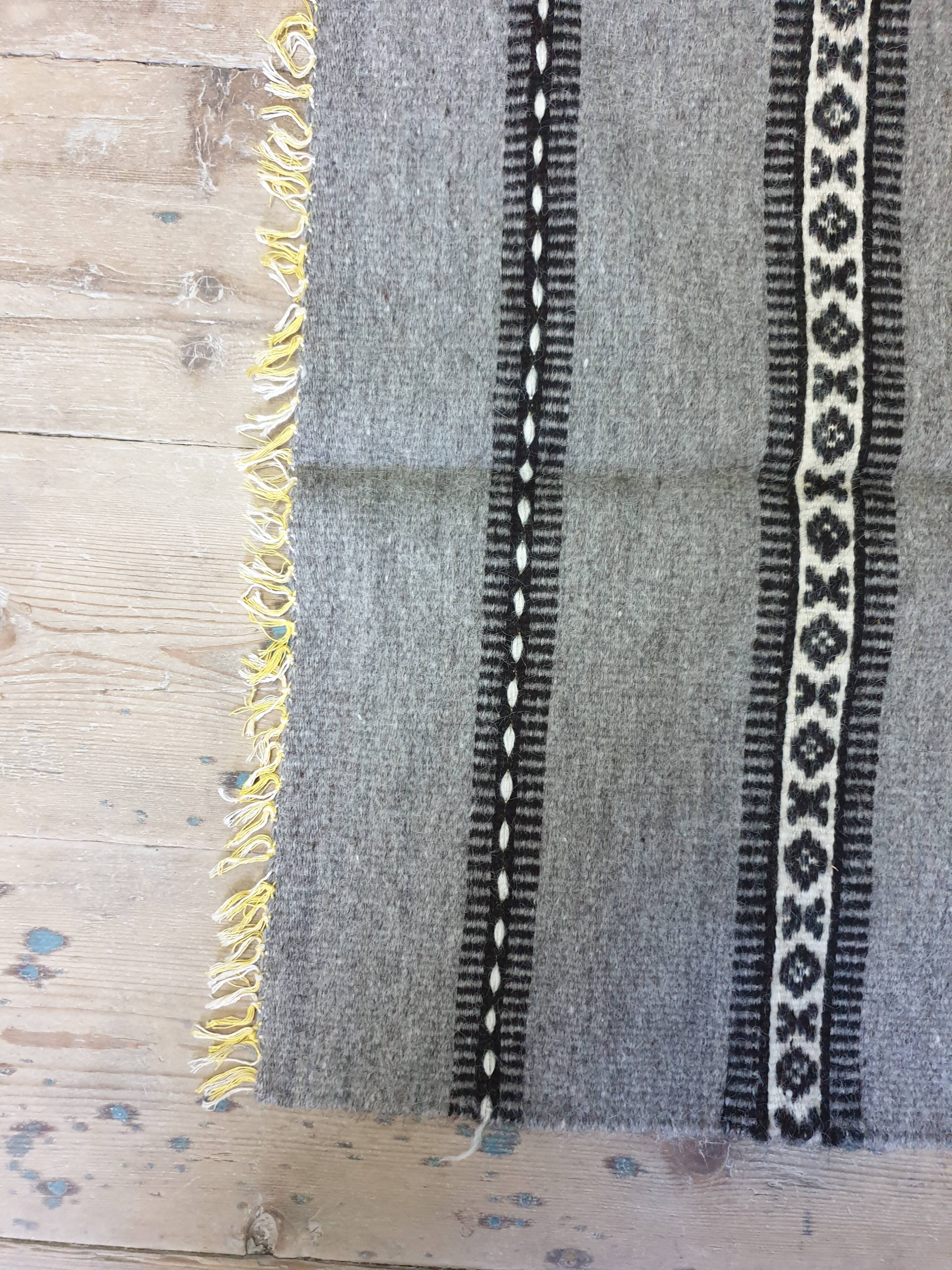 Handwoven vintage geometrical rug, grey background