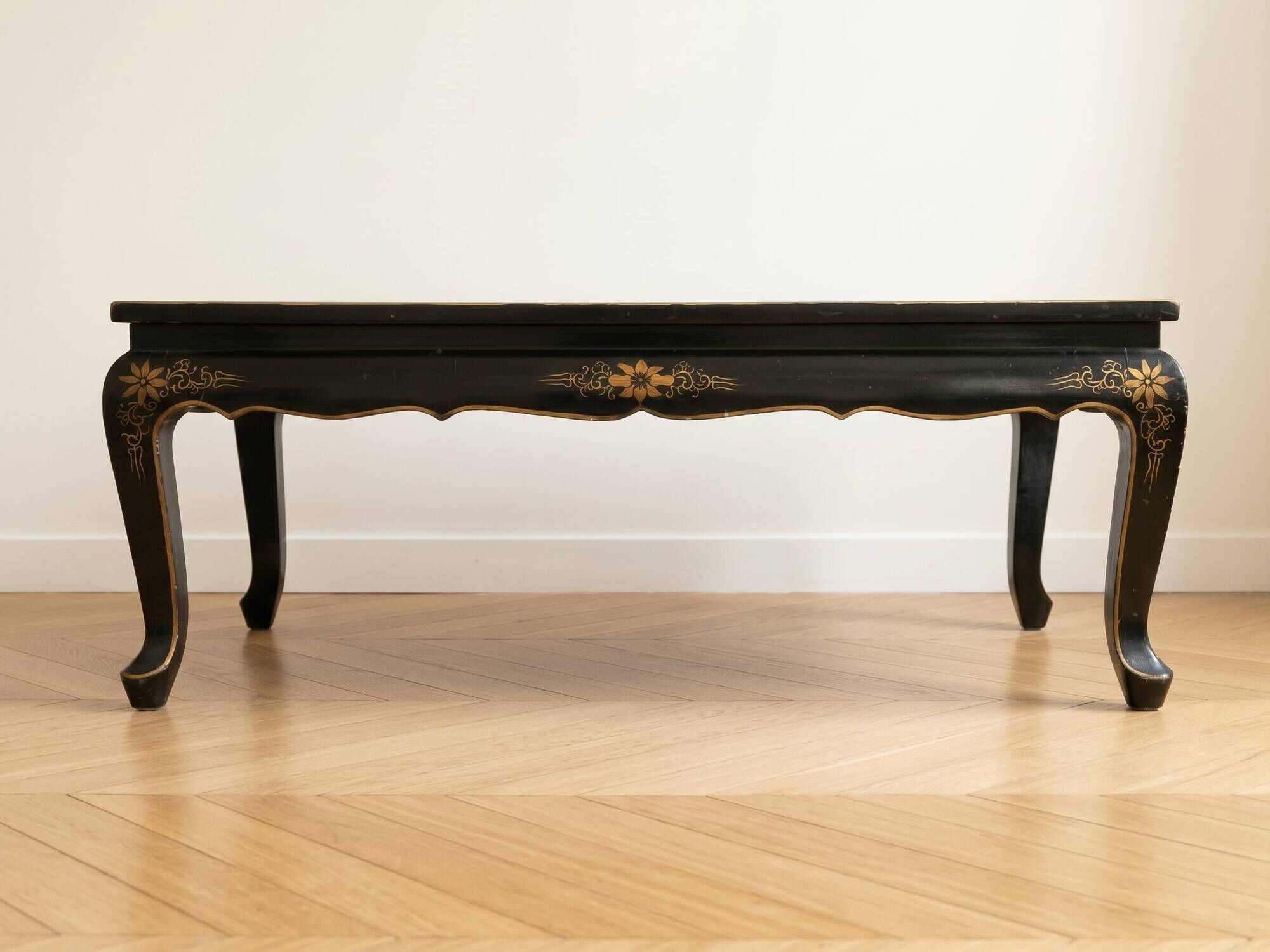Antique Chinese coffee table in black and gold lacquered wood.